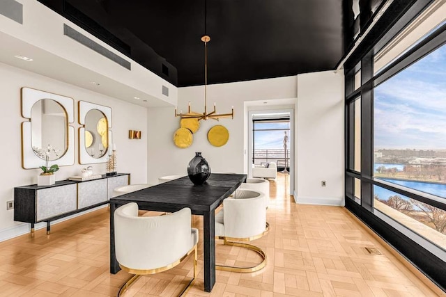 dining space with light parquet floors, a high ceiling, and a chandelier