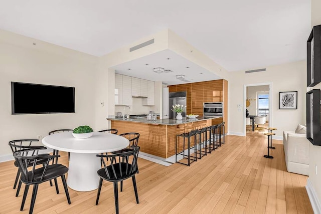 dining area featuring sink and light hardwood / wood-style floors