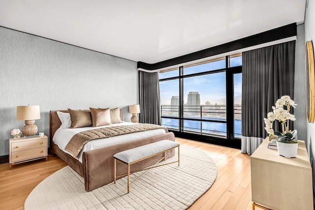 bedroom featuring access to exterior and wood-type flooring