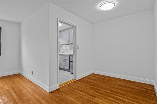 spare room featuring light wood-style floors and baseboards