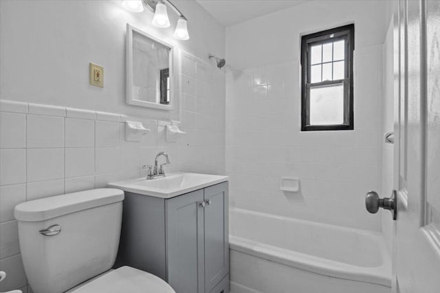 full bathroom with a wainscoted wall, tile walls, bathtub / shower combination, toilet, and vanity