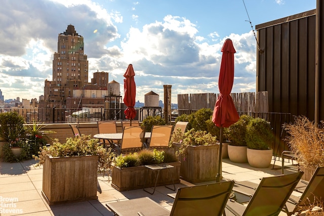 view of patio / terrace with a city view and fence