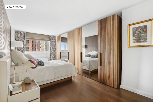 bedroom with visible vents, dark wood finished floors, and baseboards