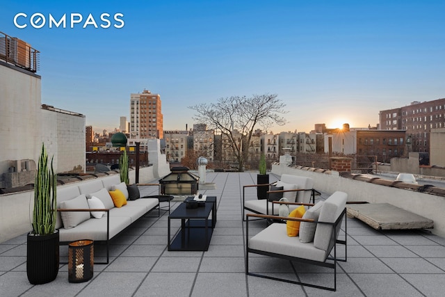 patio terrace at dusk featuring a city view and an outdoor living space