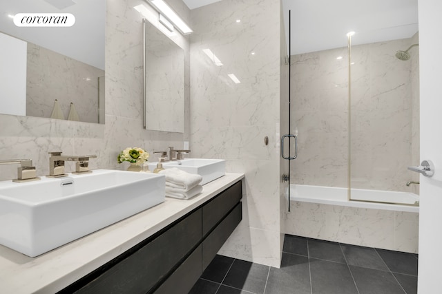 full bath featuring shower / washtub combination, a sink, visible vents, and tile walls