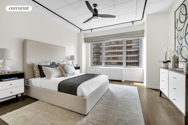 bedroom featuring ceiling fan, dark wood-type flooring, radiator heating unit, and visible vents