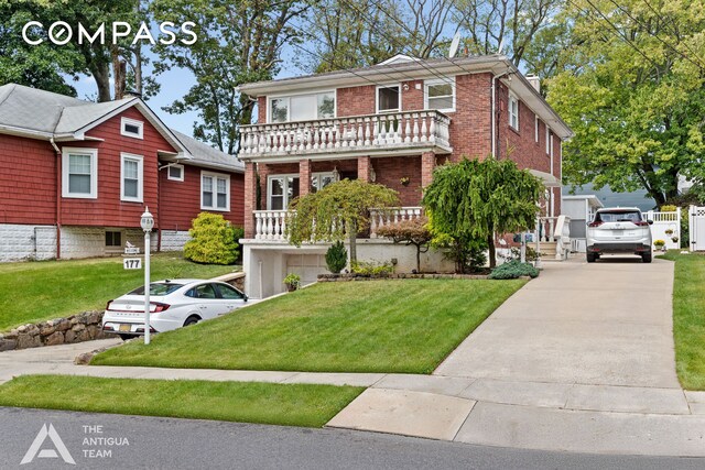 view of front of property with a balcony and a front lawn