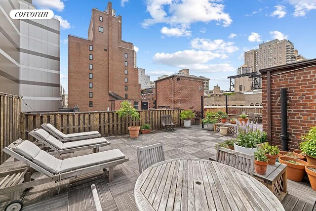 wooden terrace with outdoor dining space and a view of city