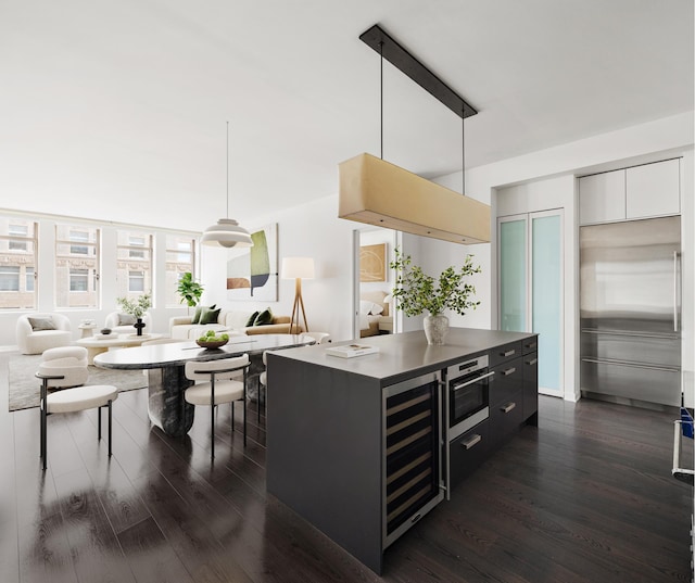 kitchen featuring dark wood-type flooring, open floor plan, decorative light fixtures, and modern cabinets