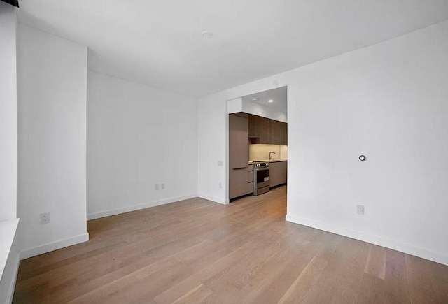 unfurnished room with sink and light hardwood / wood-style flooring