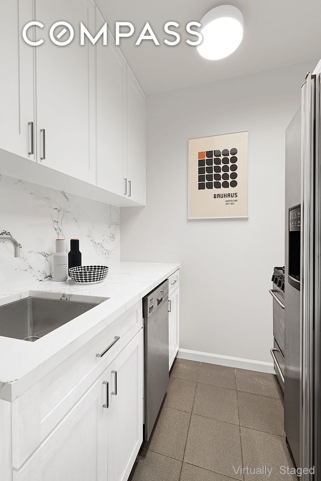 kitchen featuring white cabinets, backsplash, stainless steel appliances, and a sink