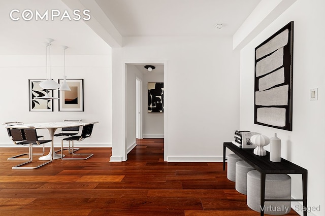 hall with baseboards and wood finished floors