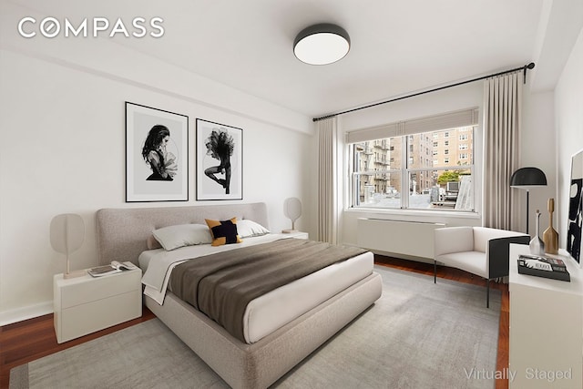 bedroom featuring baseboards and wood finished floors