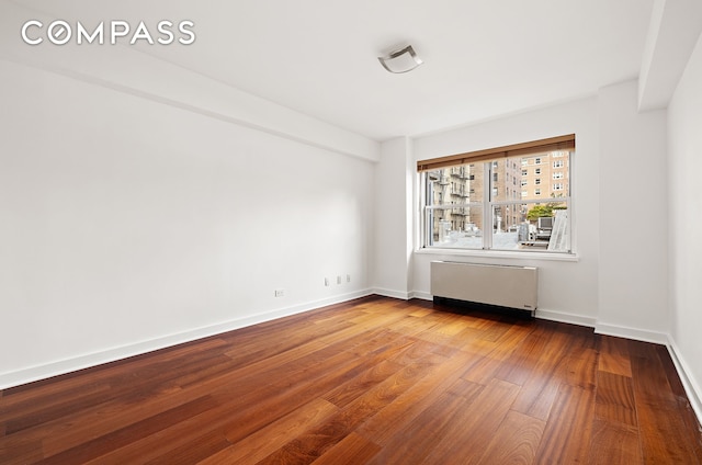 11 5th Ave Unit 7S, New York City, NY 10003 - spare room featuring radiator heating unit and wood finished floors