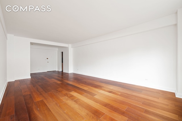 empty room featuring baseboards and wood finished floors