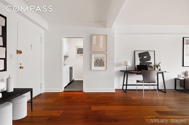 interior space featuring a baseboard heating unit, dark wood-type flooring, and baseboards