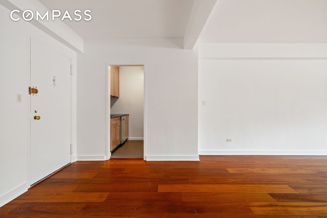 empty room with baseboards and wood finished floors