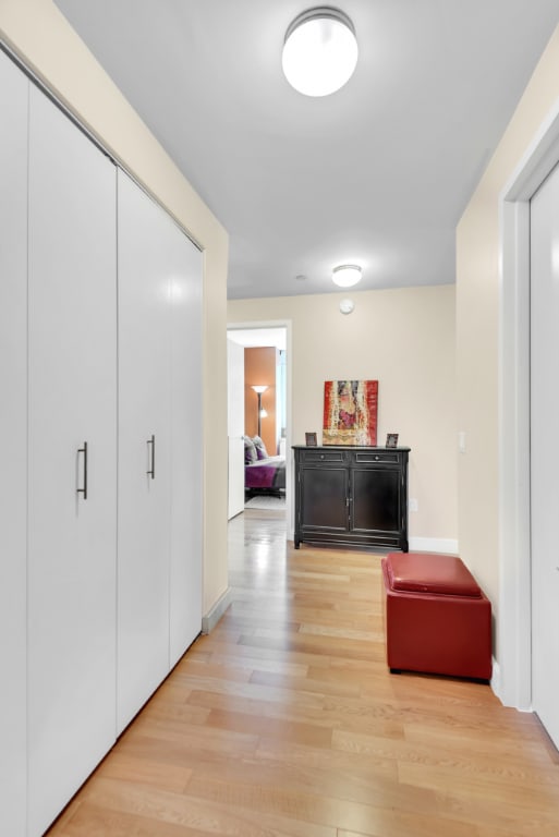 corridor featuring light wood-style flooring and baseboards