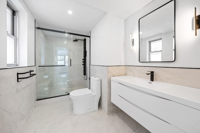 bathroom with toilet, vanity, tile walls, marble finish floor, and a stall shower