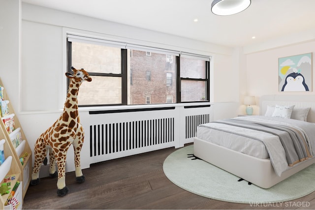 bedroom with radiator heating unit, wood finished floors, and recessed lighting