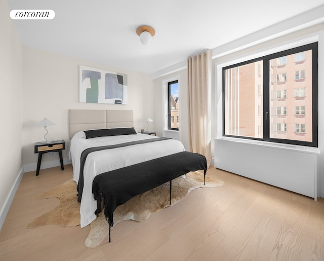 bedroom featuring visible vents, baseboards, and wood finished floors