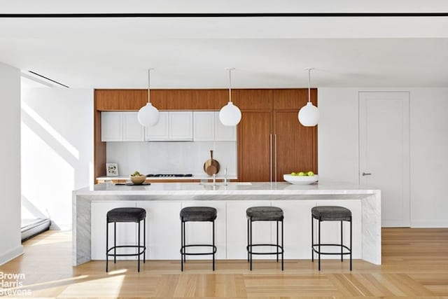 kitchen featuring pendant lighting, a breakfast bar area, a spacious island, and a sink