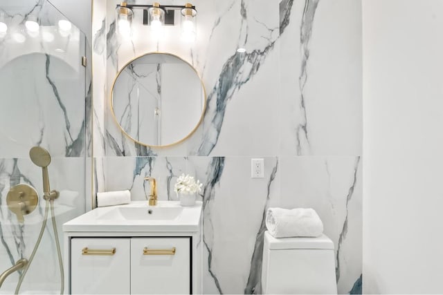 bathroom featuring toilet, tile walls, and vanity