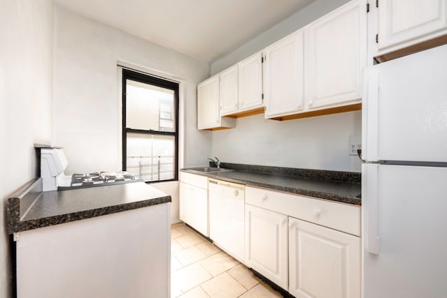 kitchen with light tile patterned flooring, white appliances, sink, and white cabinets