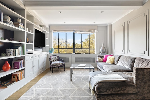 living area featuring light wood-type flooring and ornamental molding