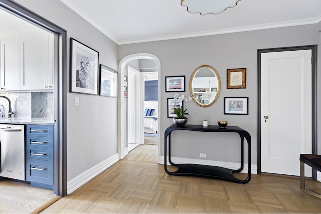 hall featuring baseboards, arched walkways, and ornamental molding