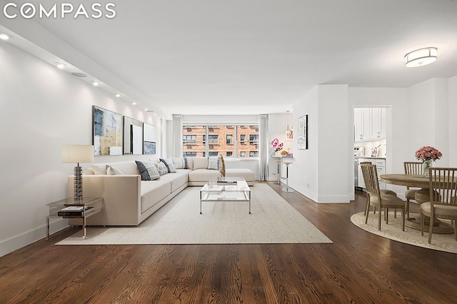 living area with baseboards and wood finished floors