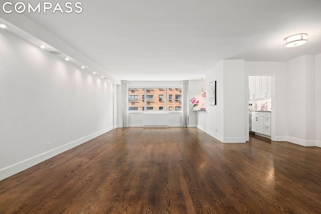 unfurnished living room featuring baseboards and dark wood-style flooring