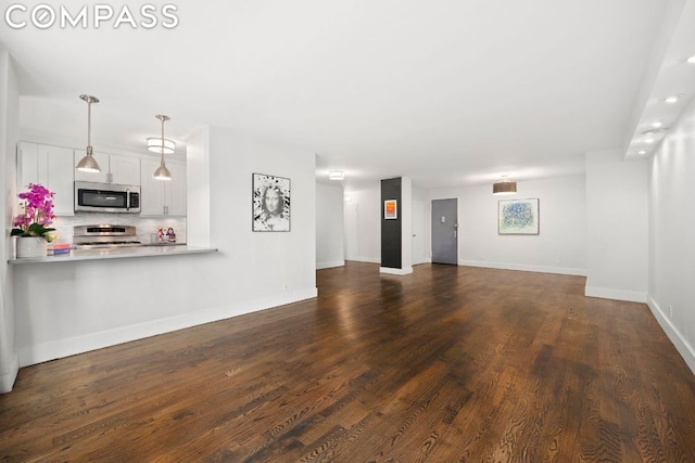 unfurnished living room with baseboards and dark wood-style flooring