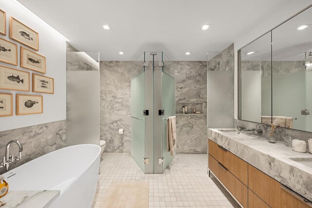 bathroom featuring tile patterned flooring, vanity, tile walls, and plus walk in shower