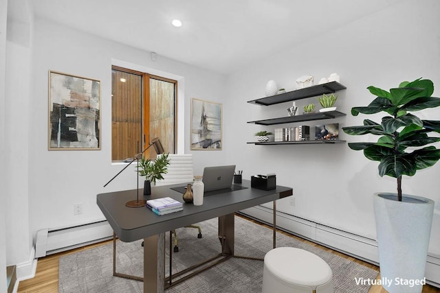 office area featuring light wood finished floors, a baseboard radiator, and baseboards