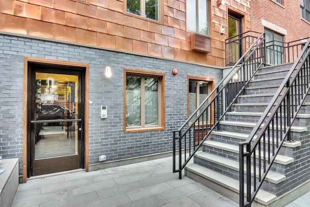 view of exterior entry featuring brick siding