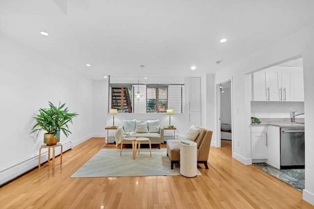 living area featuring recessed lighting, light wood-style floors, baseboards, and baseboard heating