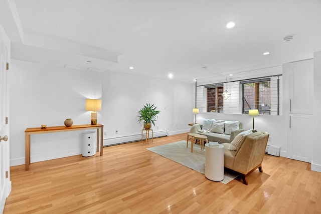 living area featuring light wood-type flooring, baseboards, baseboard heating, and recessed lighting