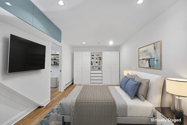 bedroom with light wood-type flooring, a baseboard heating unit, baseboards, and recessed lighting