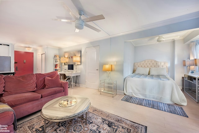 bedroom featuring crown molding, a closet, a ceiling fan, wood finished floors, and baseboards