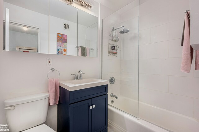 full bathroom with tiled shower / bath combo, vanity, and toilet