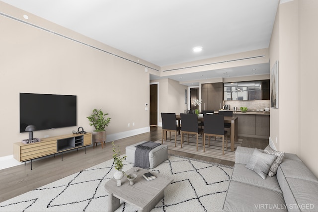 living area with recessed lighting, light wood-style flooring, and baseboards