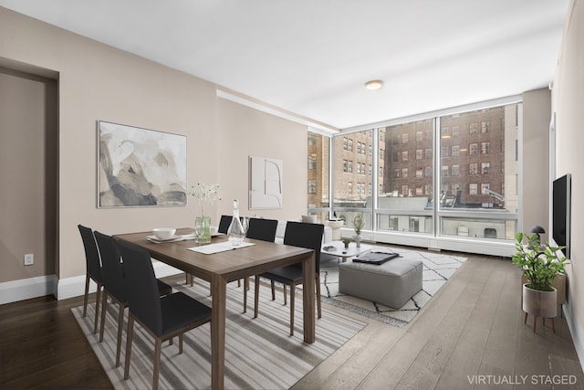 dining space with expansive windows, baseboards, and wood finished floors