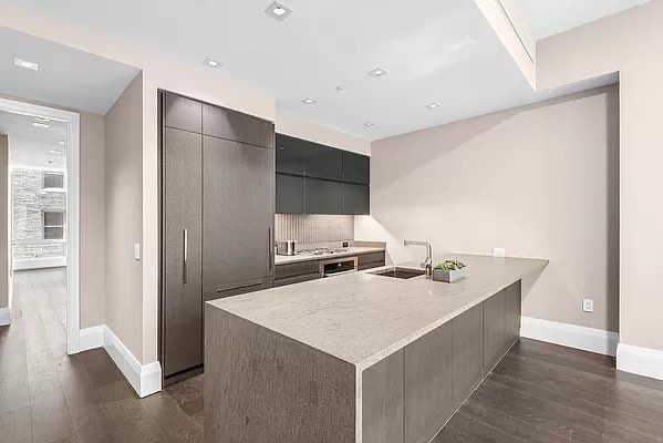 kitchen featuring tasteful backsplash, modern cabinets, dark wood-type flooring, and a sink