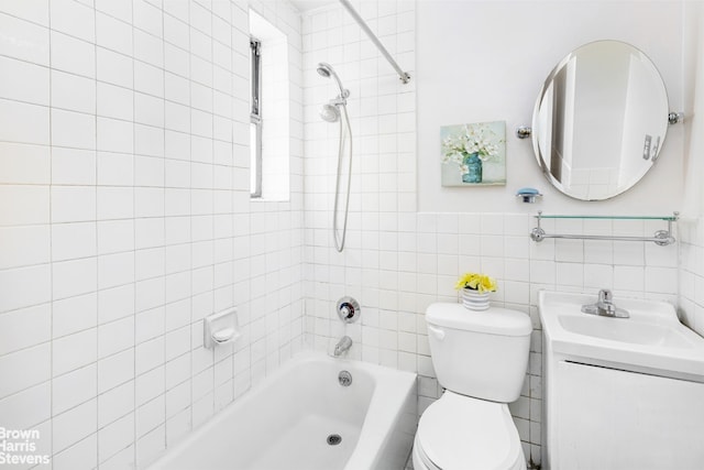 bathroom with toilet, vanity, tile walls, and shower / bathtub combination