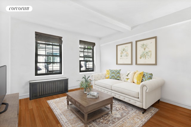 living room with hardwood / wood-style flooring, radiator, and beamed ceiling