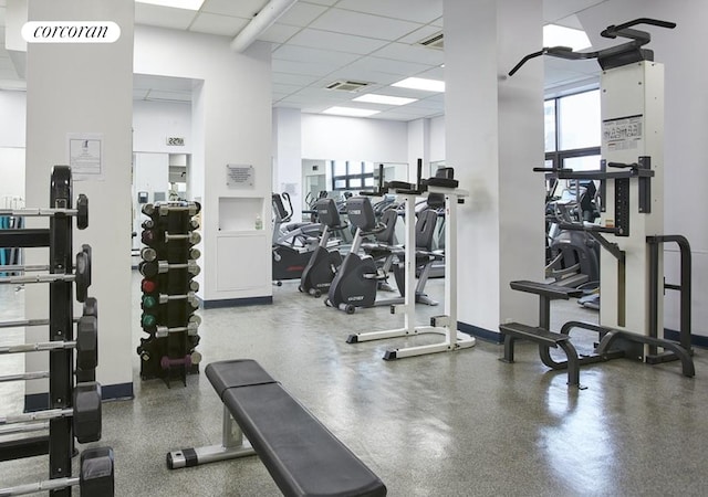 gym featuring a paneled ceiling, baseboards, and visible vents