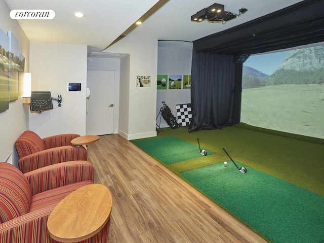 rec room with golf simulator, wood finished floors, recessed lighting, and baseboards