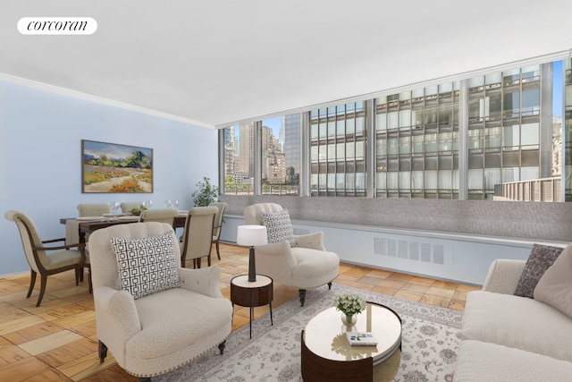 living area with ornamental molding, a city view, and baseboards