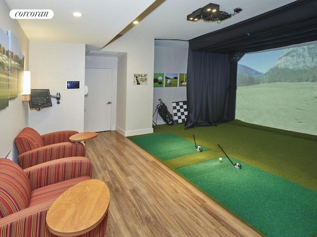 game room with golf simulator and hardwood / wood-style floors